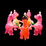 a kaiju sofubi of pink monster with gun