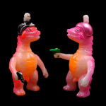 a kaiju sofubi of pink monster with gun