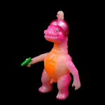 a kaiju sofubi of pink monster with gun