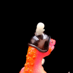 a kaiju sofubi of pink monster with gun